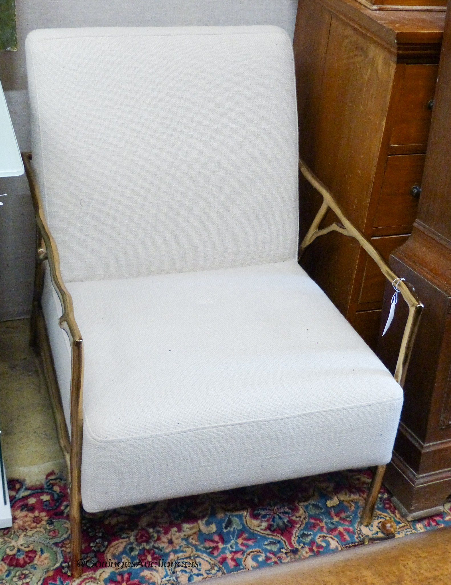 A contemporary brass and natural fabric armchair, width 63cm, depth 77cm, height 72cm
